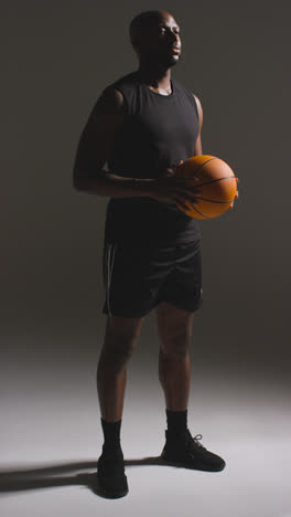 Vertical-Video-Full-Length-Studio-Shot-Of-Male-Basketball-Player-Dribbling-And-Bouncing-Ball-Against-White-Background-1